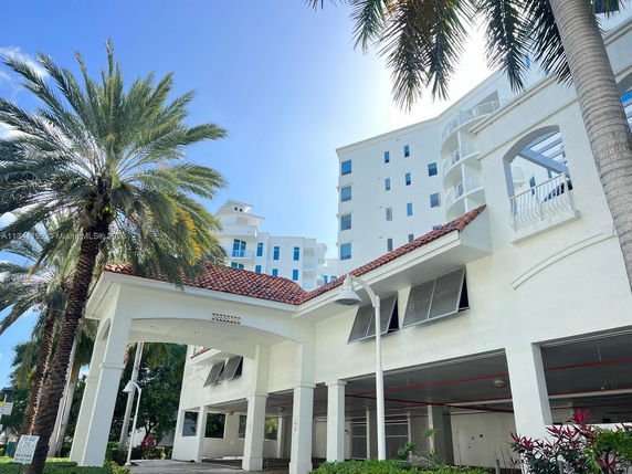 Front view of a multi-story building with a covered entrance and red-tiled roof.