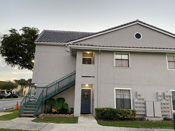 Front view of a two-story apartment building with an external staircase.