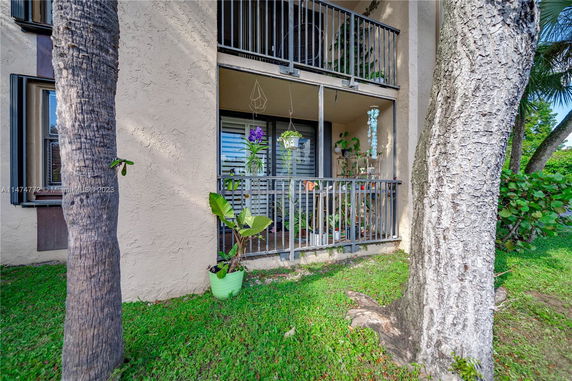 Exterior view of a building with a balcony and decorative plants.