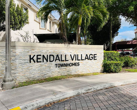 Front view of a townhomes building with a sign for Kendall Village.