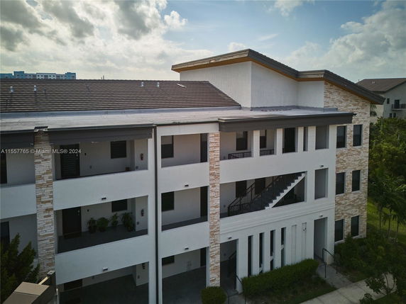 Front view of a multi-story building with balconies and stone accents.