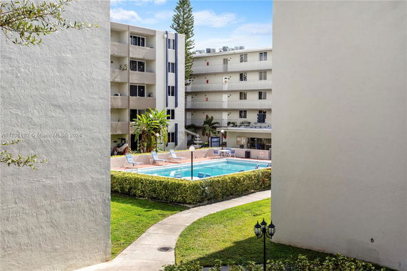 Outdoor swimming pool surrounded by multi-story residential buildings.