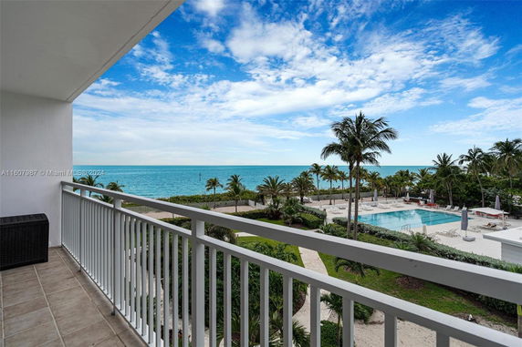 View from a balcony overlooking a swimming pool and ocean