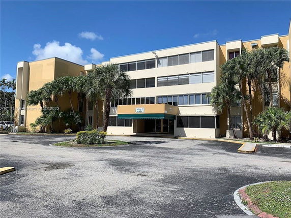 Front view of a multi-story building with palm trees.