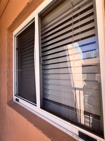 Close-up view of a window with blinds on a building exterior.