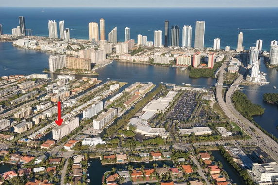 Wide aerial view of a coastal city with various high-rise buildings and waterways.