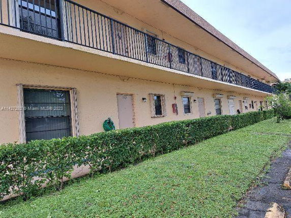 Front view of a two-story building with balconies and doors on the ground level.