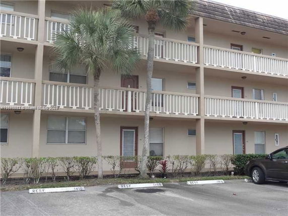 Front view of a three-story apartment building with balconies.