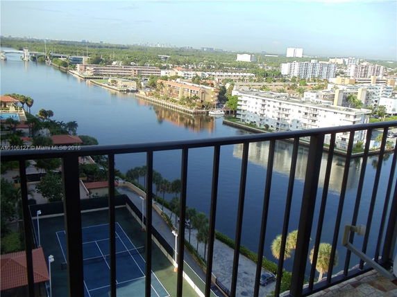 Panoramic view from a balcony overlooking a river and urban buildings.