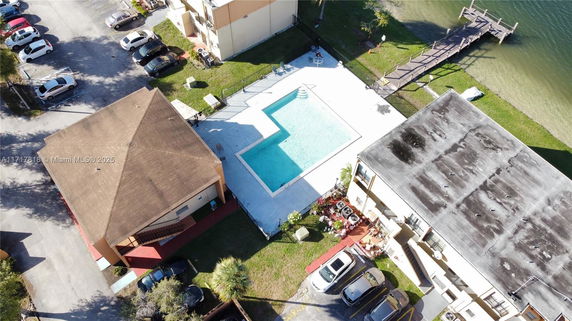 Aerial view of a residential area with a swimming pool and surrounding buildings.