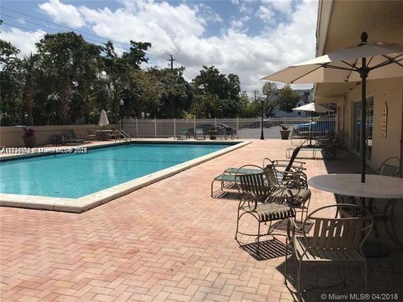 Outdoor swimming pool area with lounge chairs and umbrellas.
