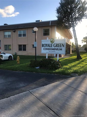 Front view of a condominium building with a sign reading 'Royale Green Condominium'.