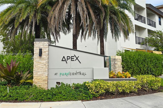 Front view of a residential building with palm trees and a sign reading 'Apex at Park Central'.