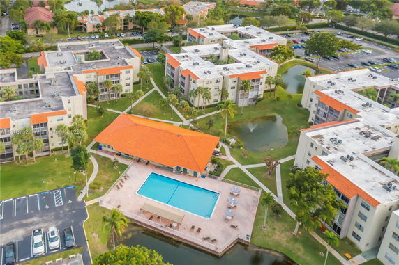 Aerial view of apartment complex with a swimming pool and landscaped grounds.