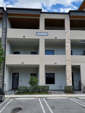 Front view of a multi-story building with stone accents and covered balconies.