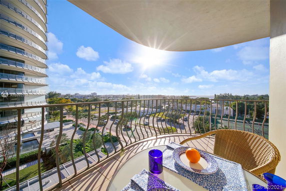 View from a balcony overlooking urban surroundings and a high-rise building.