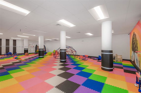 Indoor play area with colorful flooring and play equipment.