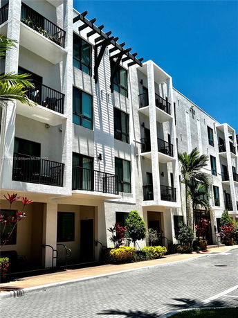 Front view of a multi-story residential building with balconies and modern design.