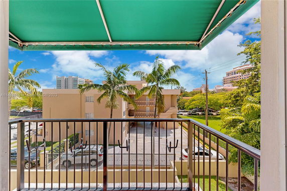 View from a balcony showing other buildings and palm trees in the vicinity.