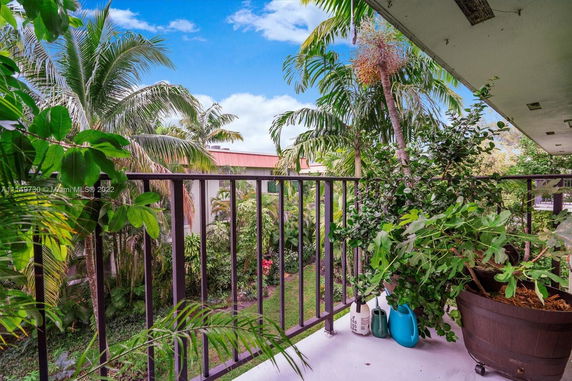 Balcony view with tropical plants and trees surrounding the area.
