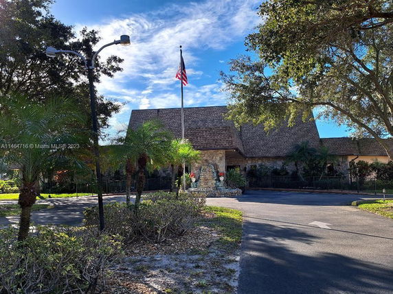 Front view of a building with a gabled roof and an American flag in front.