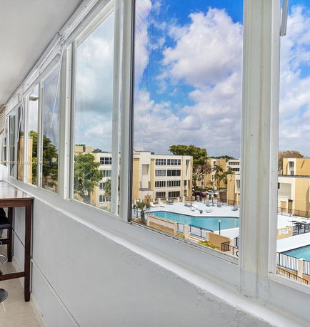 View of surrounding buildings and pool area from an enclosed balcony.