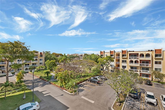 View of a residential area with multiple apartment buildings and parking spaces.