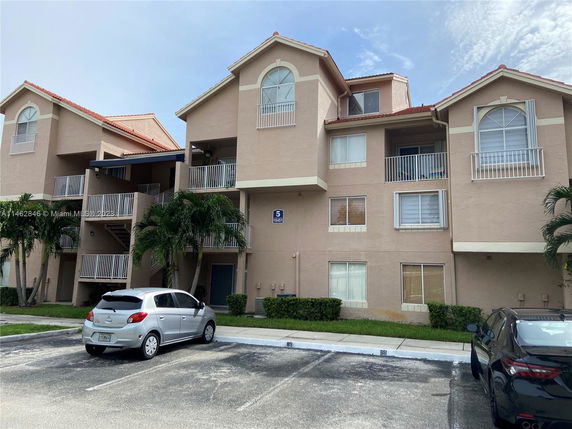 Front view of a multi-story apartment building with balconies.