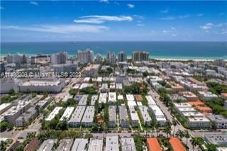 Panoramic view of a coastal cityscape with numerous buildings and the ocean in the background.