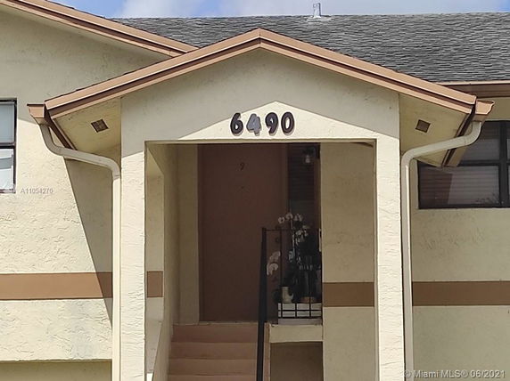 Front view of a two-story house with beige exterior and number 6490.