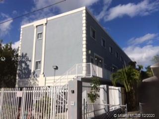 Front view of a multi-story building with a gated entrance.