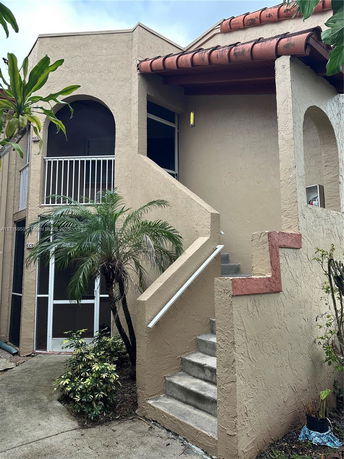 Front view of a two-story building with a staircase and balcony.