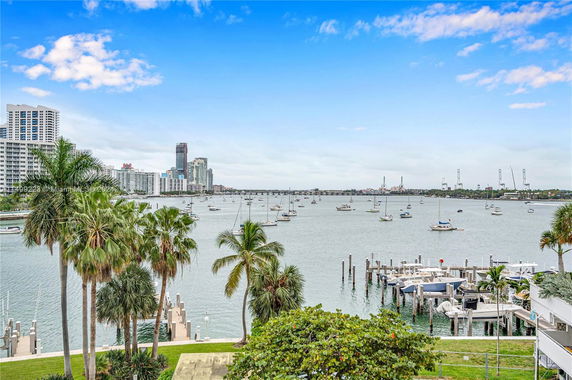 View of a waterfront with boats and high-rise buildings in the background.