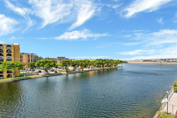 View of a river with buildings and trees along the water's edge.