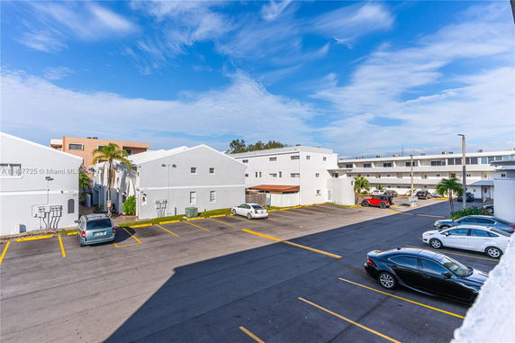Outdoor parking area in front of a multi-story building.
