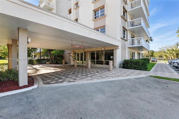 Front view of a multi-story building with balconies and an entrance canopy.