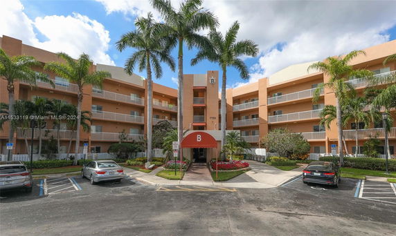 Front view of a multi-story residential building with balconies and an entrance canopy.