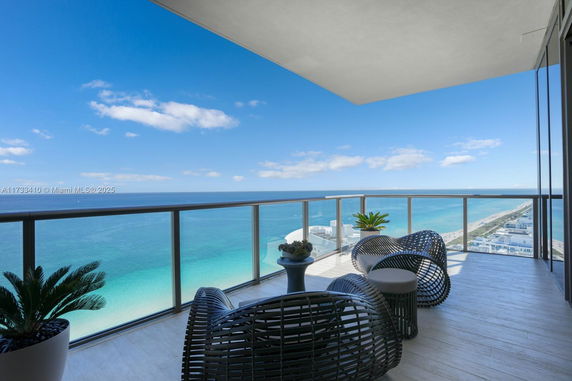 Panoramic view from a high-rise balcony overlooking the ocean and coastline.