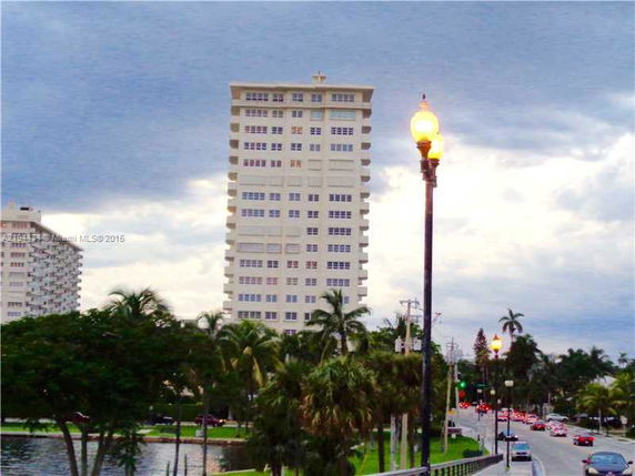 Front view of a tall apartment building with numerous windows.