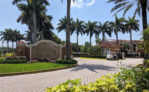 Front view of a luxury condominium entrance with palm trees.