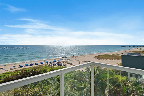 Panoramic view of a beach from a high vantage point, showing shoreline and ocean.