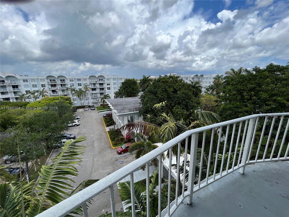 Panoramic view of a residential area with multi-story buildings and greenery from a balcony.