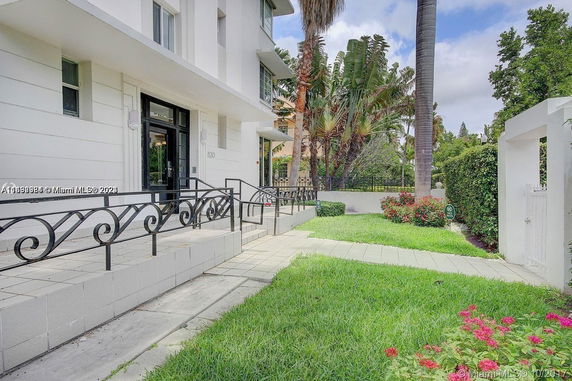 Front view of a building with black railings and a tiled pathway.