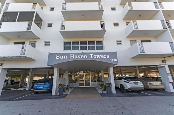 Front view of a multi-story residential building with balconies.