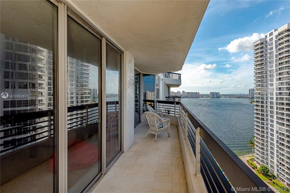 Balcony view overlooking a body of water and surrounding high-rise buildings.