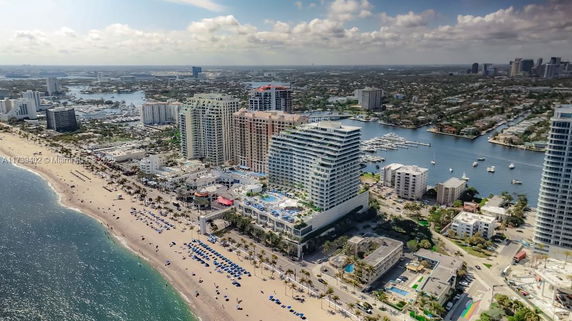 Aerial view of a coastal cityscape with tall buildings and a beach.