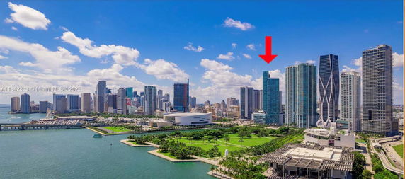 Skyline view of a coastal city with several high-rise buildings and a waterfront park.