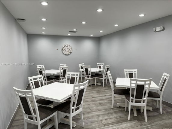 Indoor room with multiple tables and chairs, simple decor.
