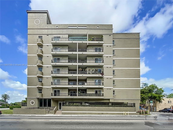 Front view of a multi-story apartment building with balconies.