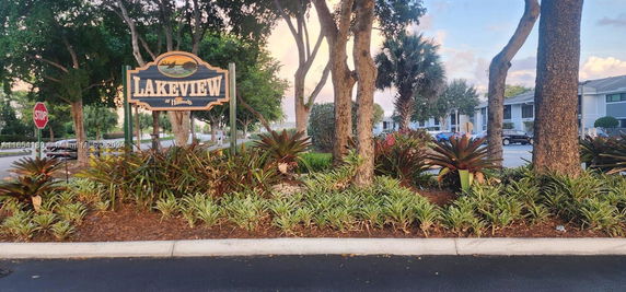 Sign for Lakeview in a landscaped area with trees and plants.